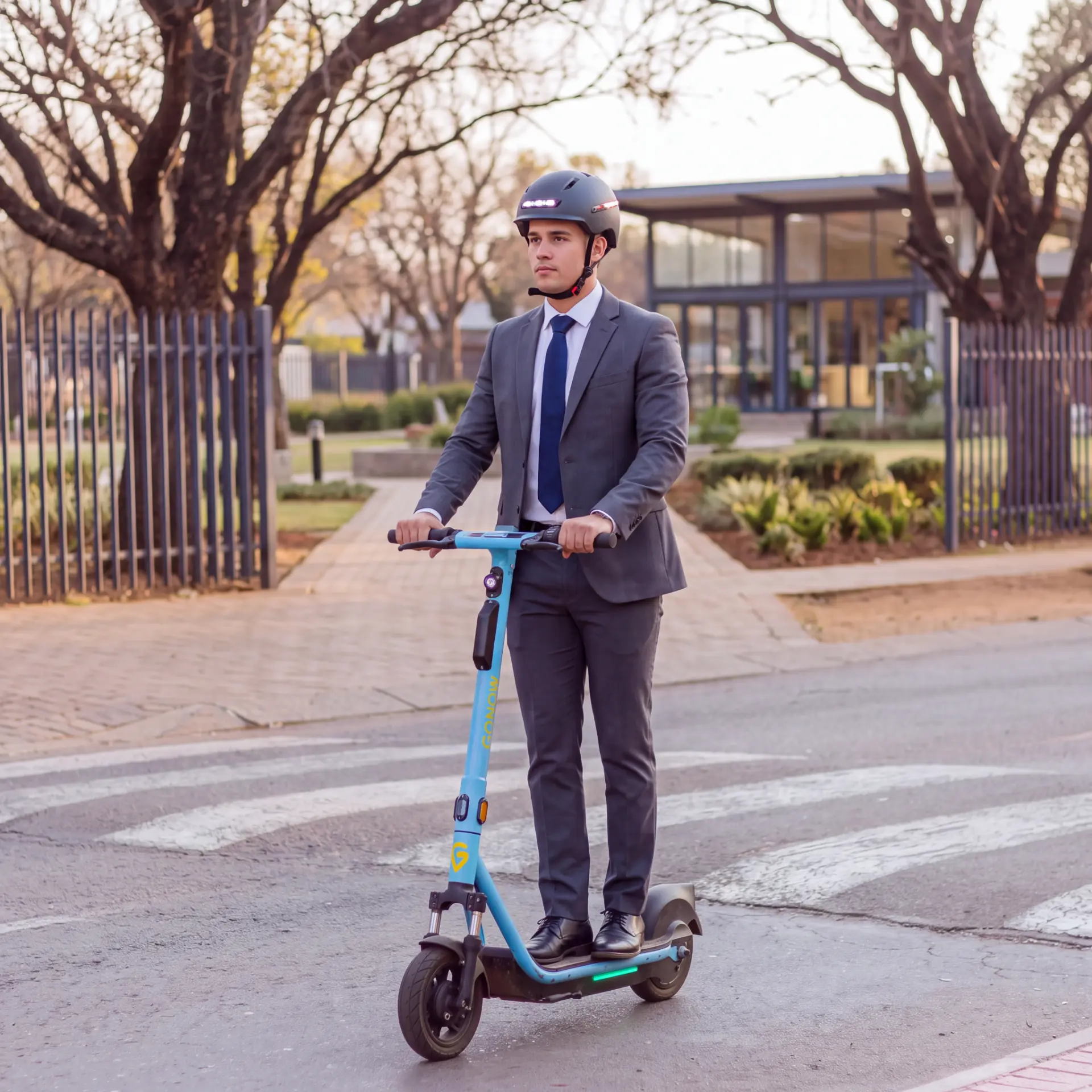 Commuter in a suit riding a GONOW scooter